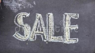 单词SALE用粉笔写在黑板上。 字在粉笔上盘旋.